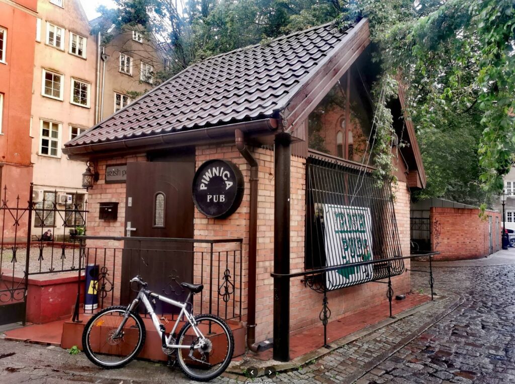 Ett litet hus på innergården med texten Piwnica Pub